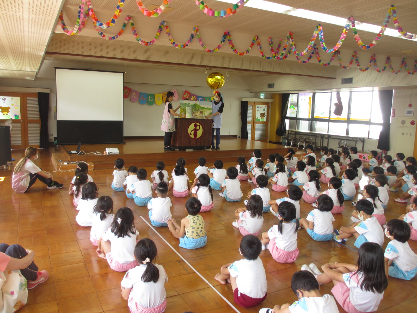 先生からの絵本の読み聞かせ。子苑には大型絵本がたくさんあります。子どもたちは毎回楽しみにしています。