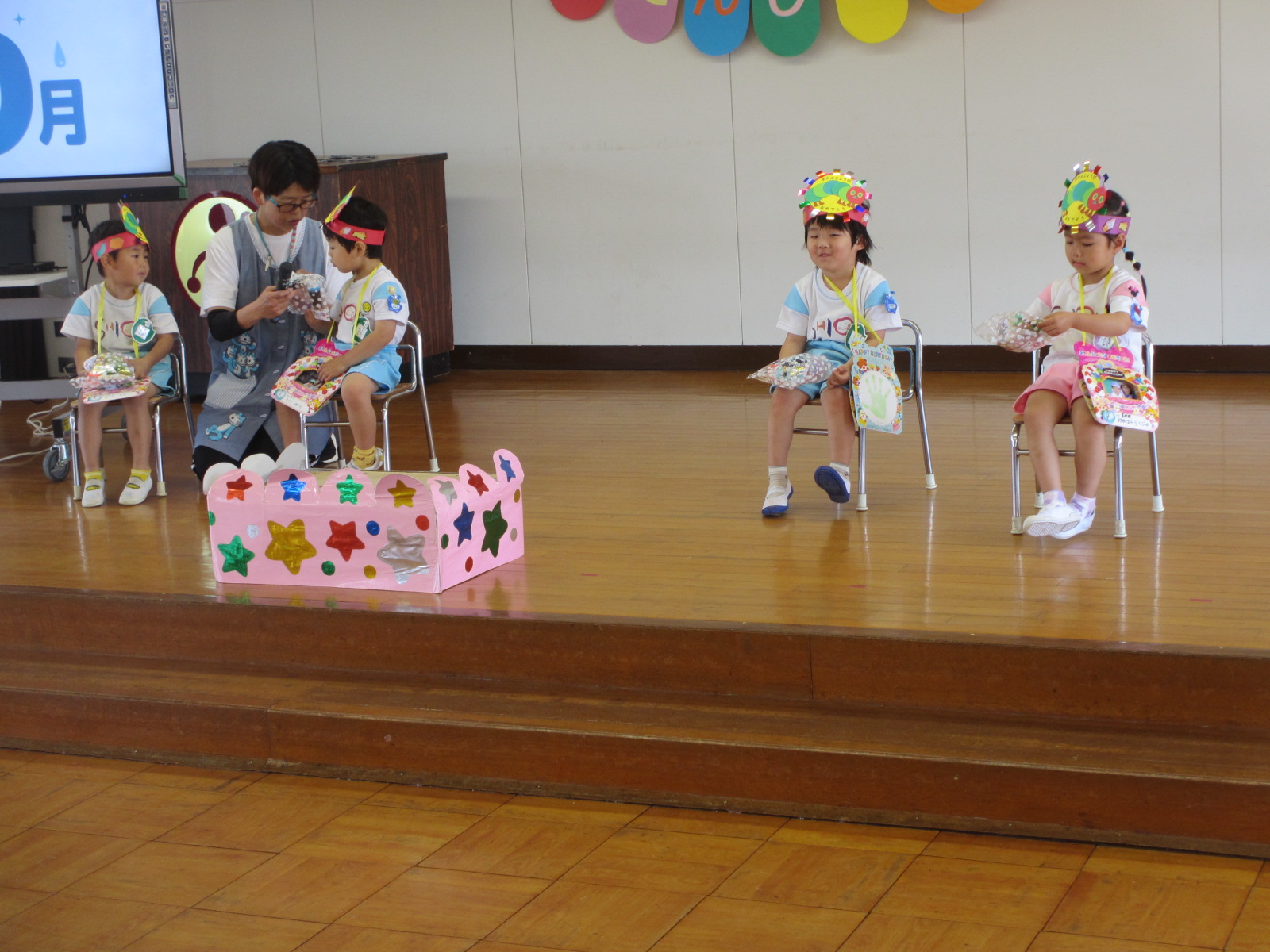４人のお友だちに子苑会からプレゼントです。「何が入っているのかな？」
